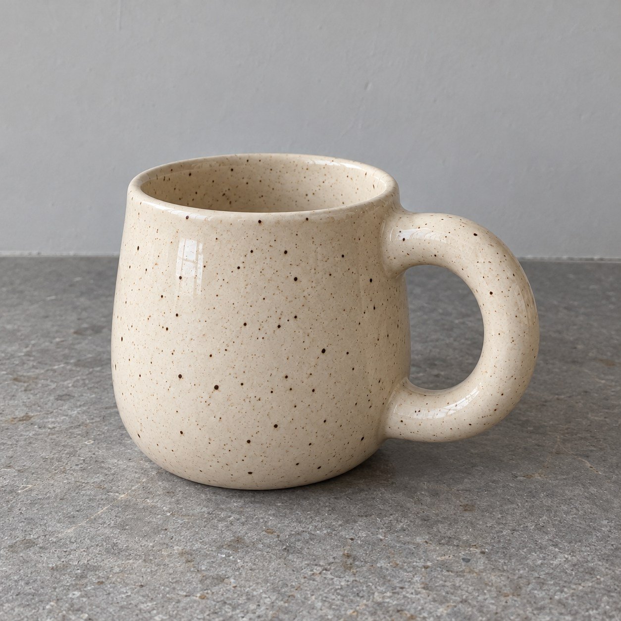 AI-generated starting photograph of a cream mug on a gray kitchen worktop